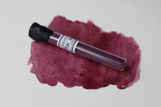 Purple ink cartridge on a purple ink smear with 'London' branding.